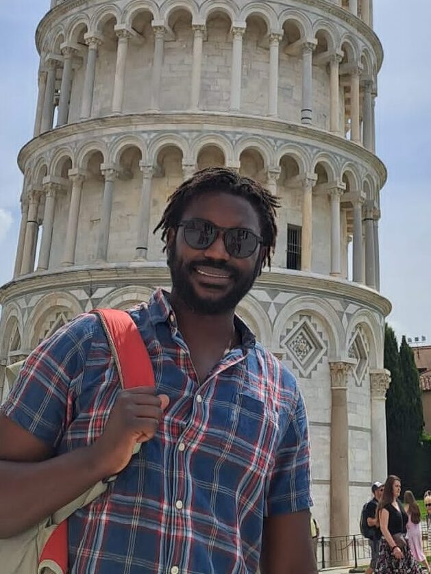 Simbarashe Kenneth Shamu standing in front of the leaning tower of the leaning tower of Pisa