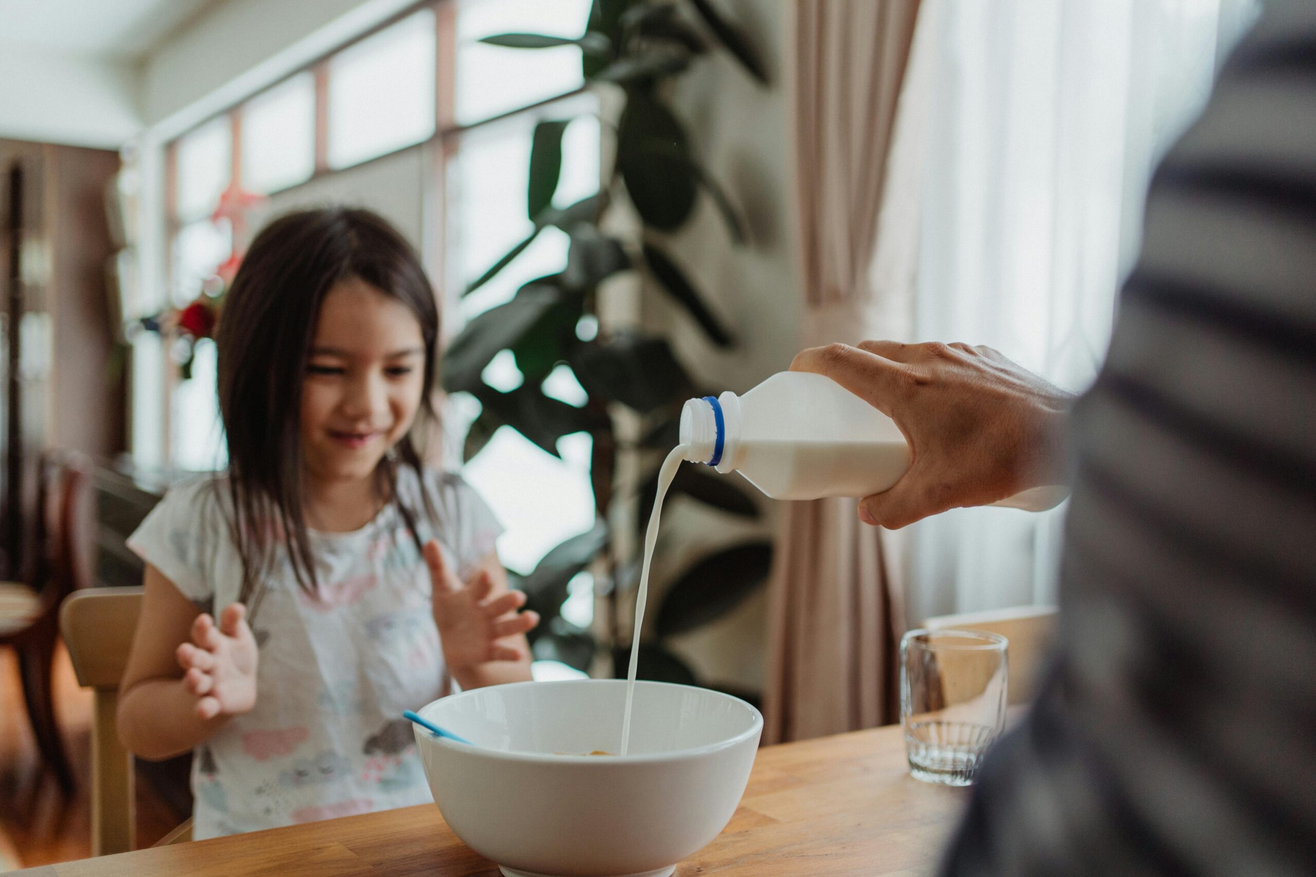 Parent and child sitting together at a kitchen table in a UK home, using simple Applied Behaviour Analysis (ABA) strategies to support positive behaviour.